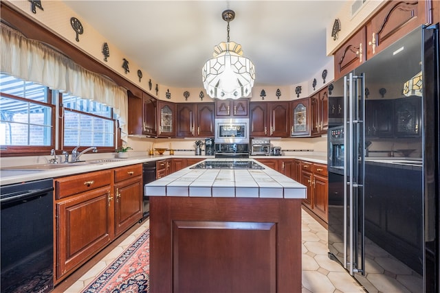 kitchen with tile countertops, hanging light fixtures, sink, black appliances, and a center island