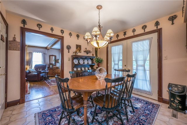 dining space with a chandelier, french doors, and light wood-type flooring