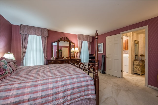 unfurnished bedroom with washer / dryer, ensuite bath, and light colored carpet