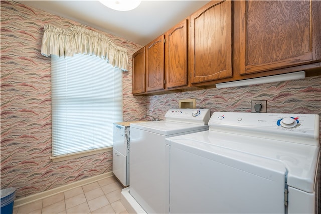 laundry area featuring cabinets, washer and dryer, and light tile patterned floors