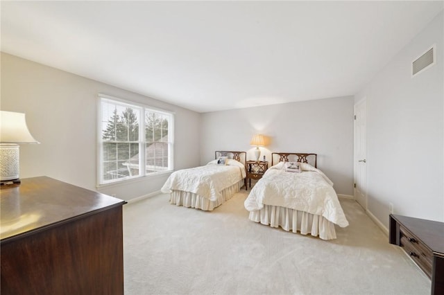 bedroom featuring baseboards, visible vents, and light colored carpet