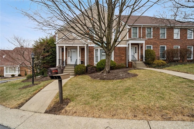 view of front facade with brick siding and a front lawn