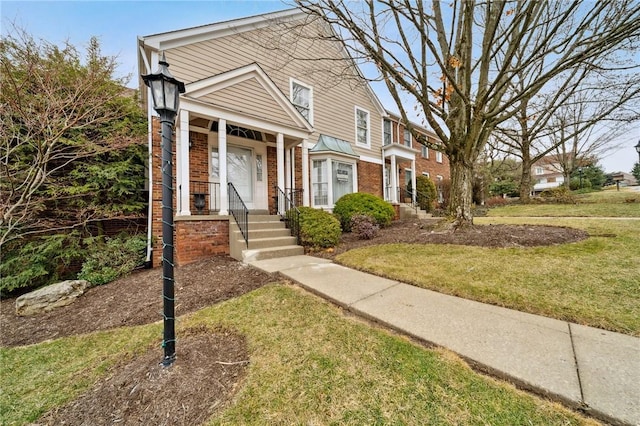 view of front of home featuring brick siding and a front yard