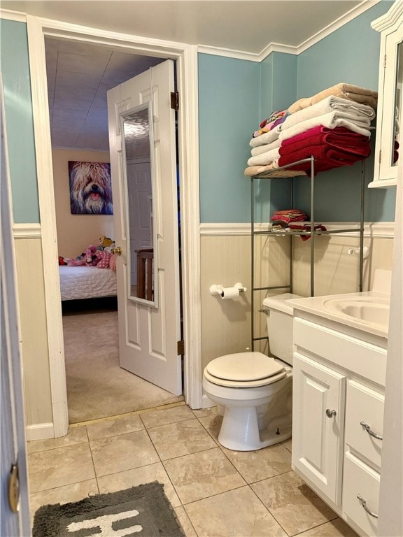 bathroom with vanity, toilet, tile patterned floors, and ornamental molding