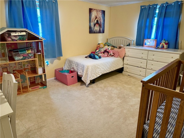 bedroom featuring ornamental molding and light carpet