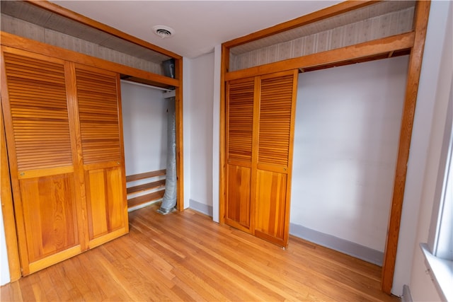 unfurnished bedroom with a closet and light wood-type flooring