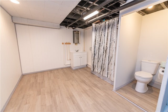 basement featuring sink and light hardwood / wood-style flooring