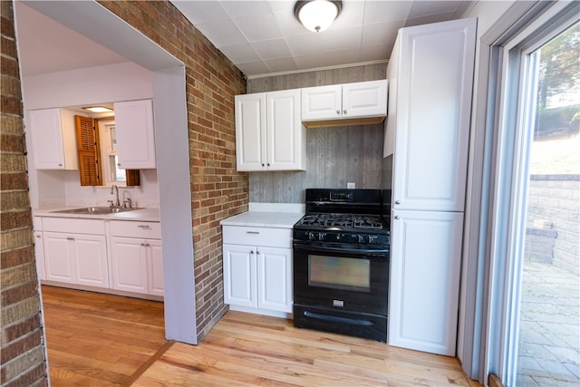 kitchen with white cabinetry, black gas stove, and sink