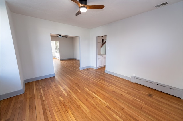 unfurnished room with a baseboard heating unit, light hardwood / wood-style floors, and ceiling fan