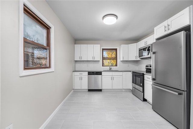 kitchen featuring sink, decorative backsplash, white cabinetry, and stainless steel appliances