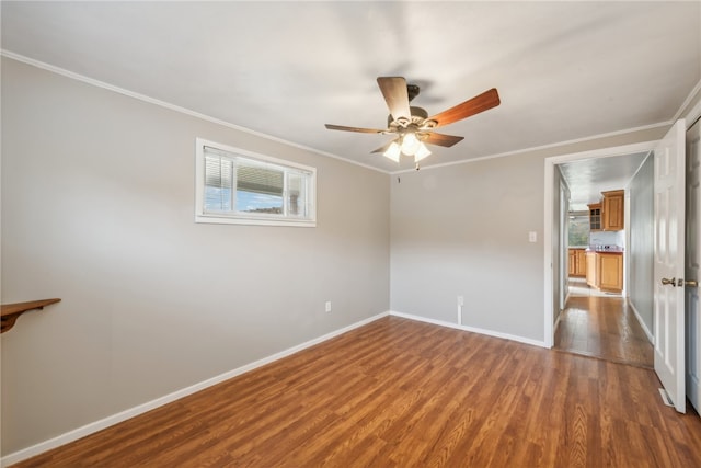 unfurnished room featuring dark wood-type flooring, ceiling fan, and ornamental molding