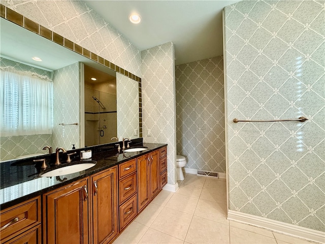 bathroom with vanity, toilet, a shower, and tile patterned flooring