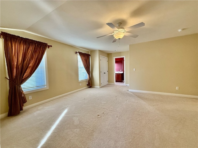 carpeted empty room with ceiling fan and lofted ceiling