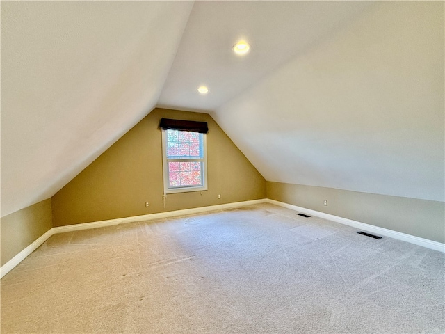 bonus room with lofted ceiling and carpet flooring