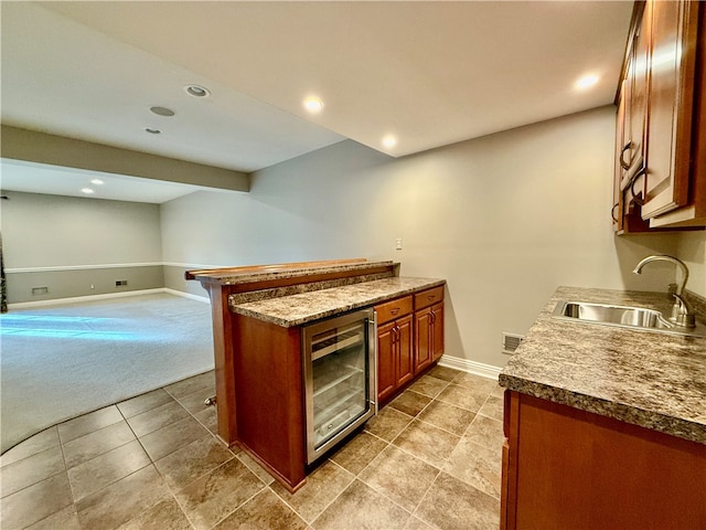 kitchen with sink, light colored carpet, and beverage cooler