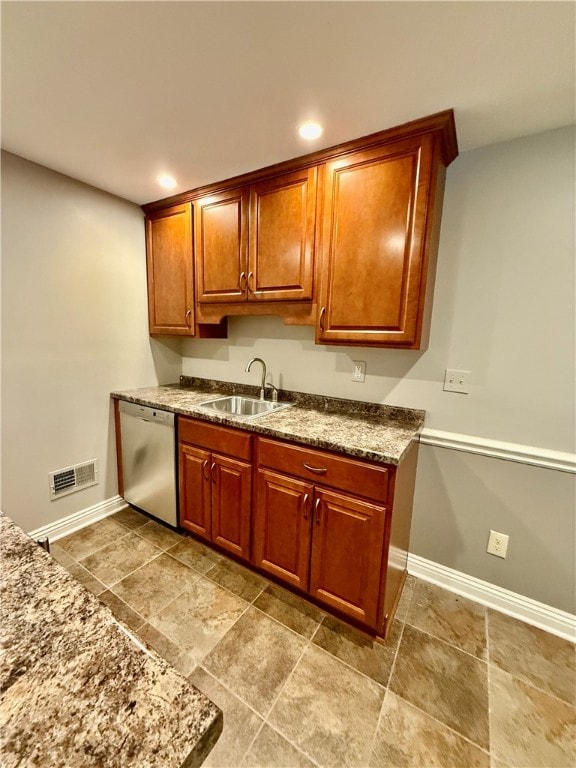 kitchen featuring stainless steel dishwasher, sink, and stone countertops