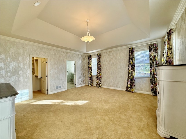 unfurnished bedroom with a spacious closet, crown molding, light carpet, and a raised ceiling