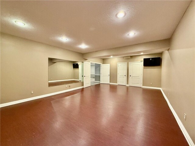 empty room with wood-type flooring and a textured ceiling