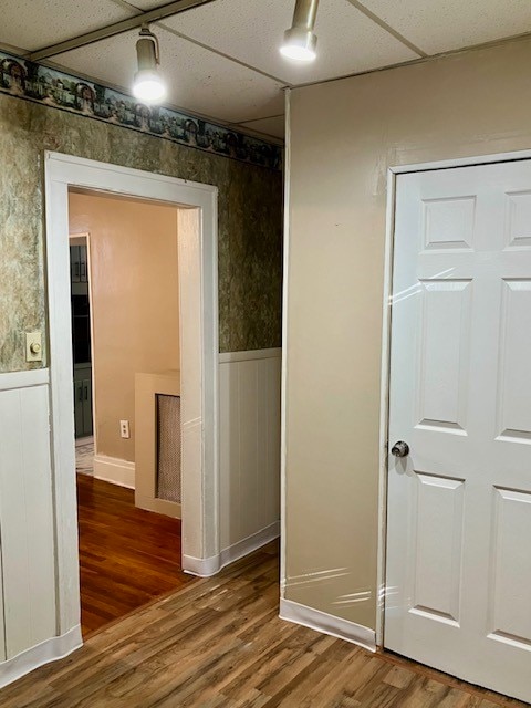 hallway with a drop ceiling and hardwood / wood-style flooring