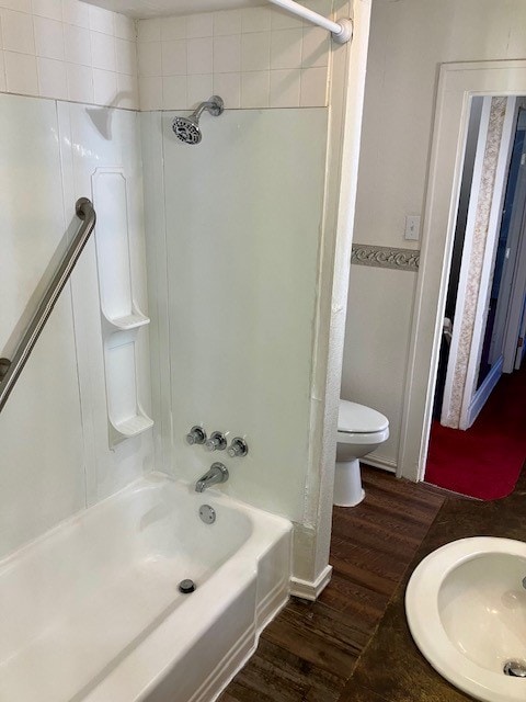 full bathroom featuring sink, toilet, wood-type flooring, and shower / tub combination