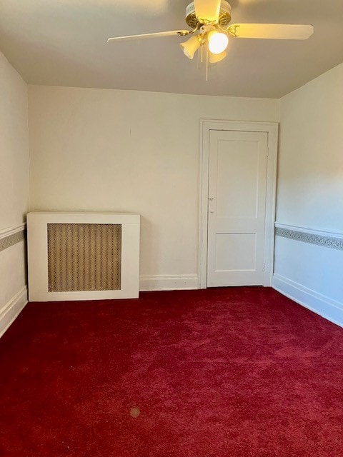 unfurnished room featuring radiator heating unit, carpet, and ceiling fan