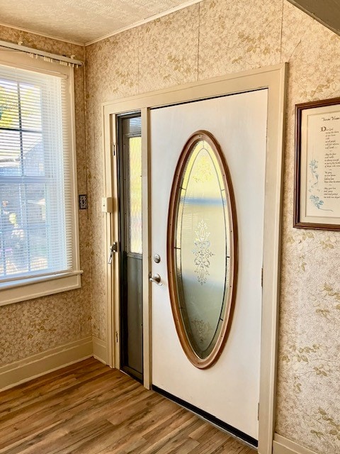 doorway to outside with a textured ceiling and hardwood / wood-style flooring