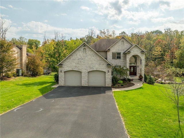 french country home with a front lawn and a garage