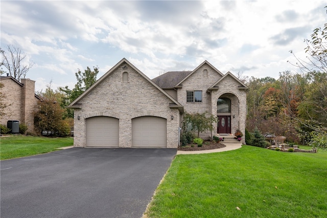 french country style house featuring a garage and a front yard