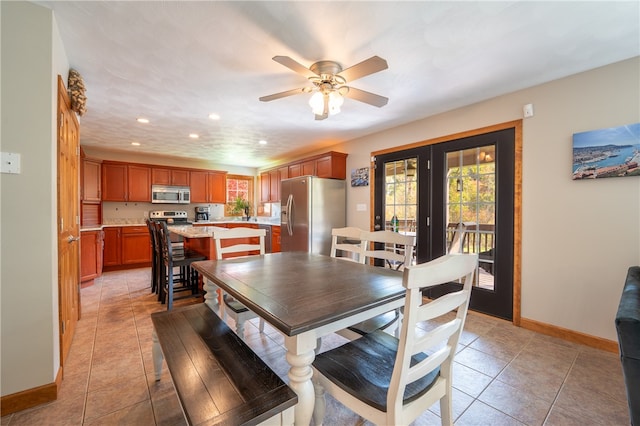 tiled dining space with ceiling fan, a healthy amount of sunlight, and french doors