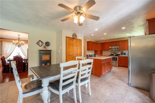 dining space with a textured ceiling, ceiling fan with notable chandelier, and light tile patterned flooring