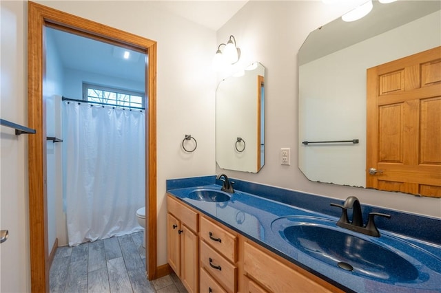 bathroom featuring vanity, hardwood / wood-style flooring, toilet, and curtained shower