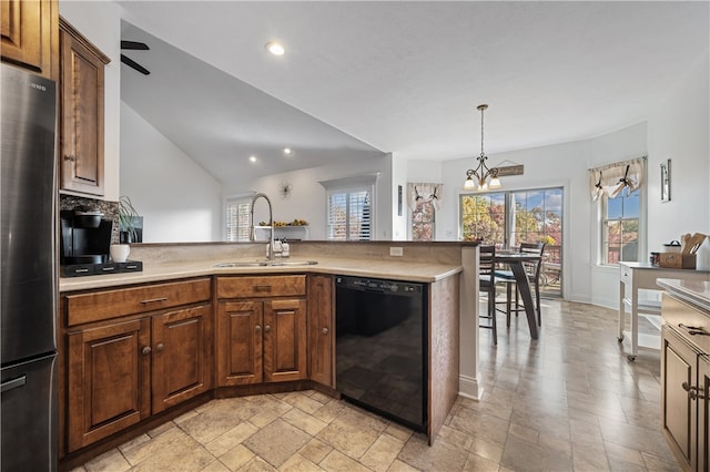 kitchen with lofted ceiling, dishwasher, sink, an inviting chandelier, and stainless steel refrigerator