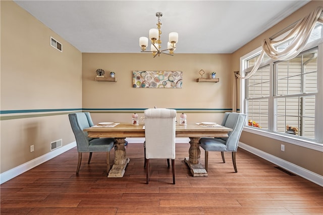 dining area with a notable chandelier and hardwood / wood-style floors