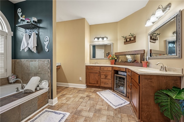 bathroom featuring wine cooler, vanity, and tiled bath