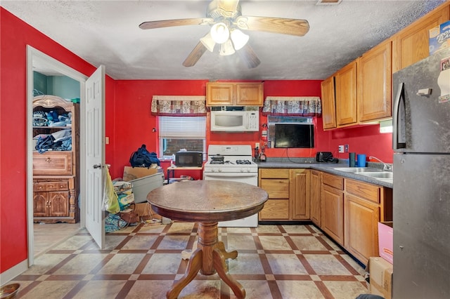 kitchen with white appliances, ceiling fan, a textured ceiling, and sink