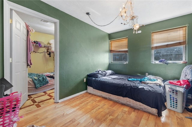 bedroom featuring hardwood / wood-style flooring and a chandelier