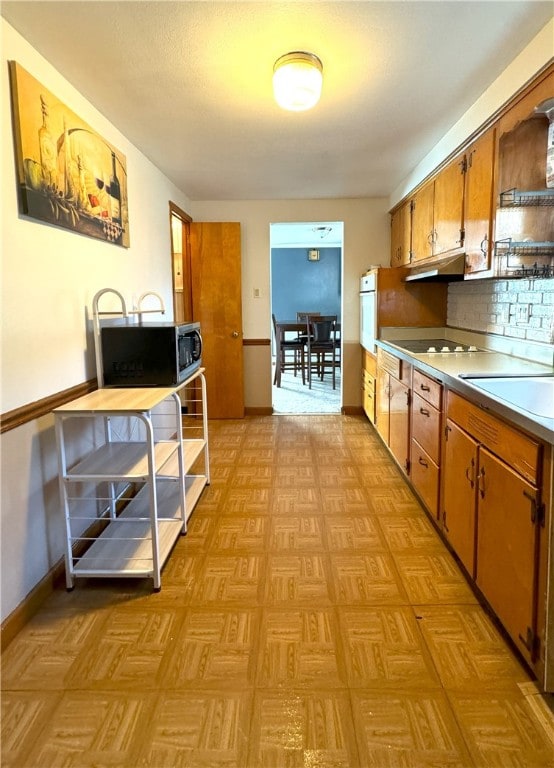 kitchen with sink, white oven, light parquet flooring, and tasteful backsplash