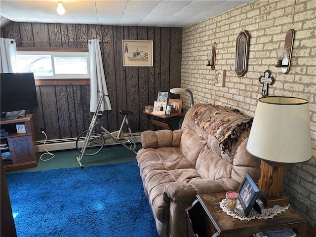 living room featuring dark carpet, brick wall, wooden walls, and a baseboard heating unit