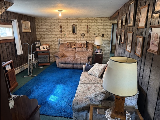 carpeted living room featuring brick wall, a textured ceiling, a baseboard heating unit, and wooden walls