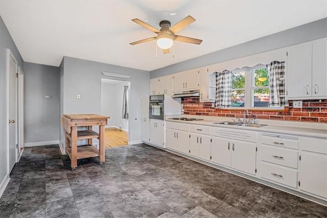 kitchen with gas cooktop, ceiling fan, sink, white cabinets, and black oven