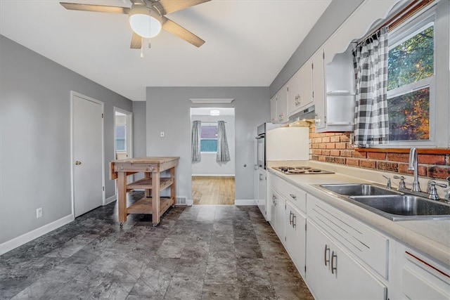 kitchen with ceiling fan, sink, white gas cooktop, decorative backsplash, and white cabinets