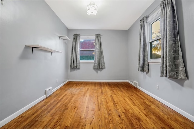 spare room featuring hardwood / wood-style flooring and plenty of natural light