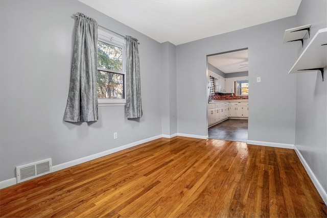 unfurnished room with hardwood / wood-style flooring