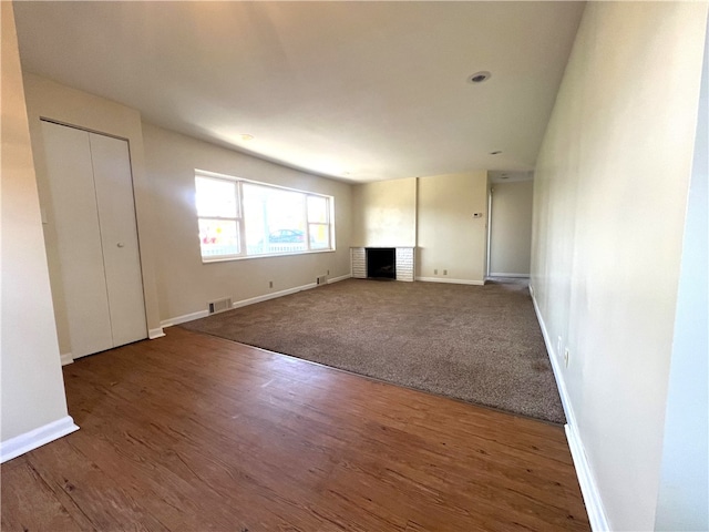 unfurnished living room featuring hardwood / wood-style flooring and a fireplace