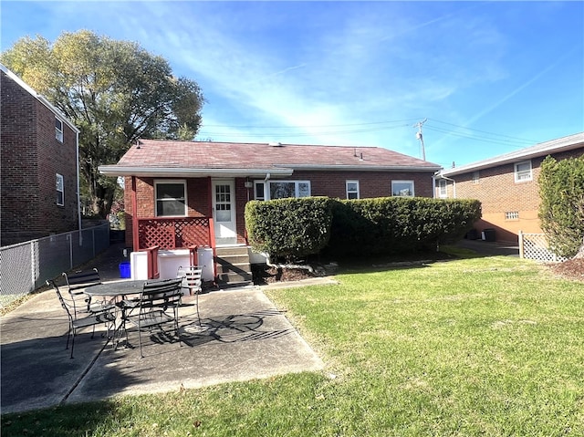 back of house with a patio and a lawn