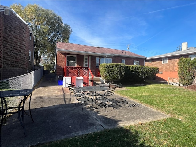 back of property with a patio area and a yard