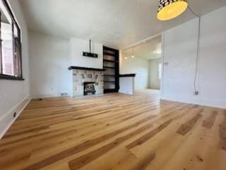 unfurnished living room featuring a fireplace and wood finished floors