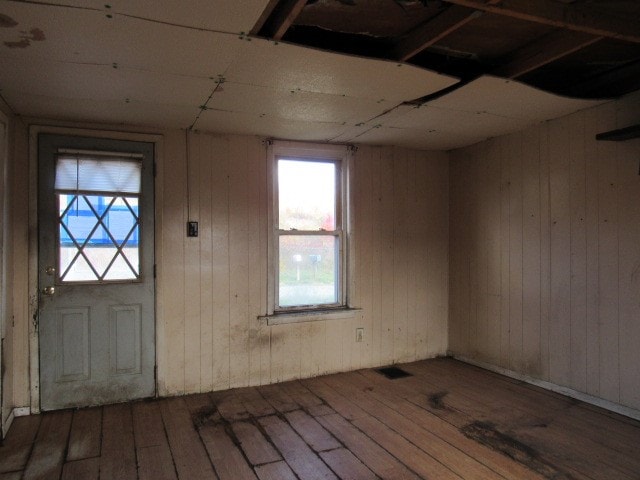 foyer entrance featuring wood walls and dark hardwood / wood-style flooring