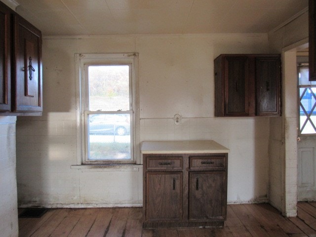 kitchen with tile walls, dark brown cabinetry, and dark hardwood / wood-style floors