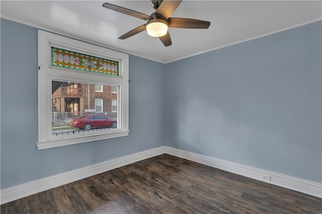 empty room with ornamental molding, dark wood-type flooring, and ceiling fan